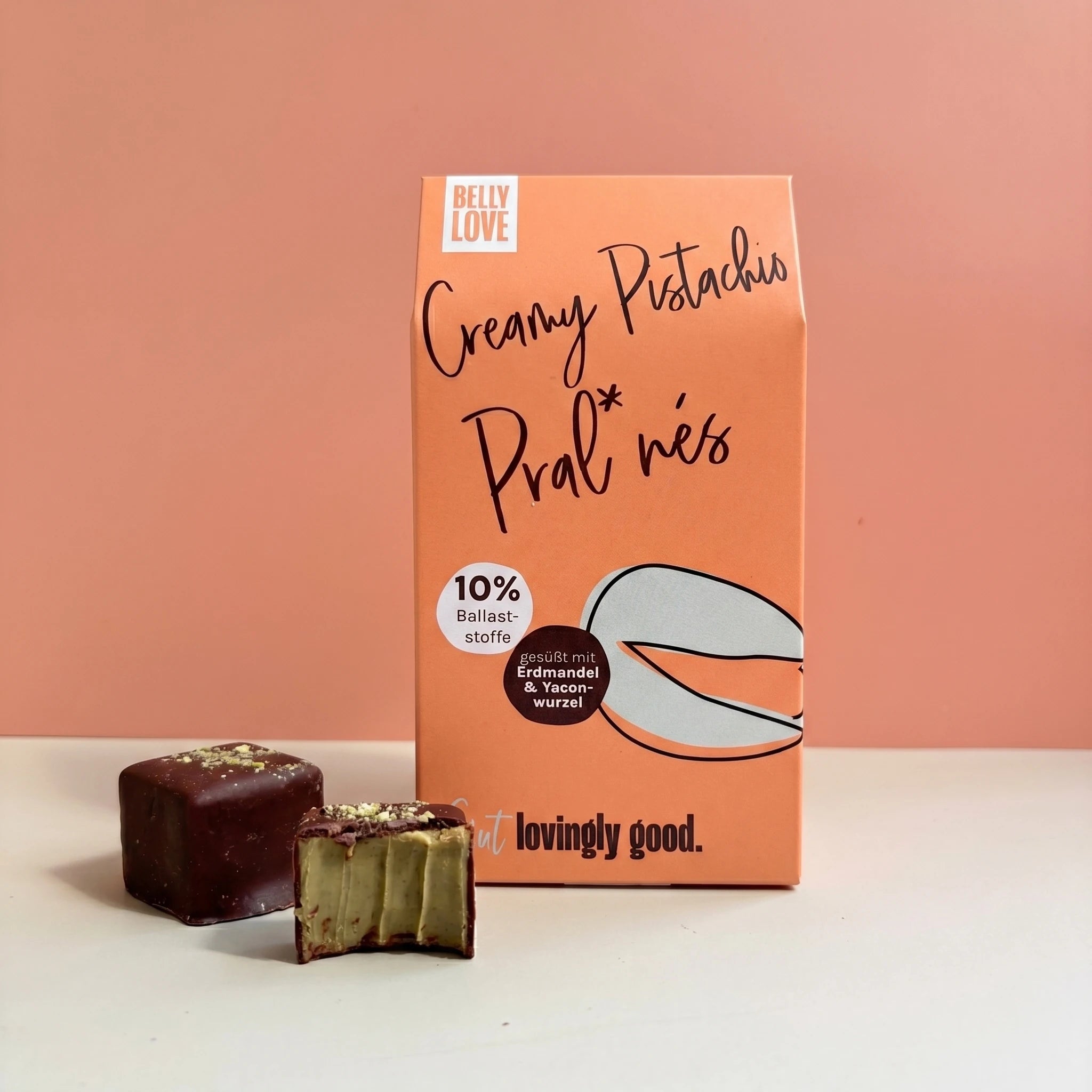 Creamy Pistachio Pralinés von Belly Love – Verpackung mit Pralinés, eine angebissen