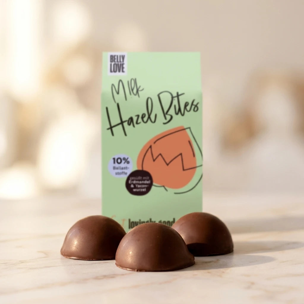 Belly Love Milk Hazel Bites im Café – dunkle Schokoladenpralinés mit Verpackung, bio-zertifizierter Genuss für unterwegs