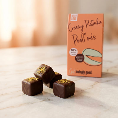 Belly Love Pistachio Pralinés auf Marmor, Verpackung bokeh – industriezuckerfrei