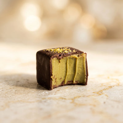 Pistachio Pralinés von Belly Love – Anschnitt zeigt cremige grüne Pistazien-Ganache-Füllung